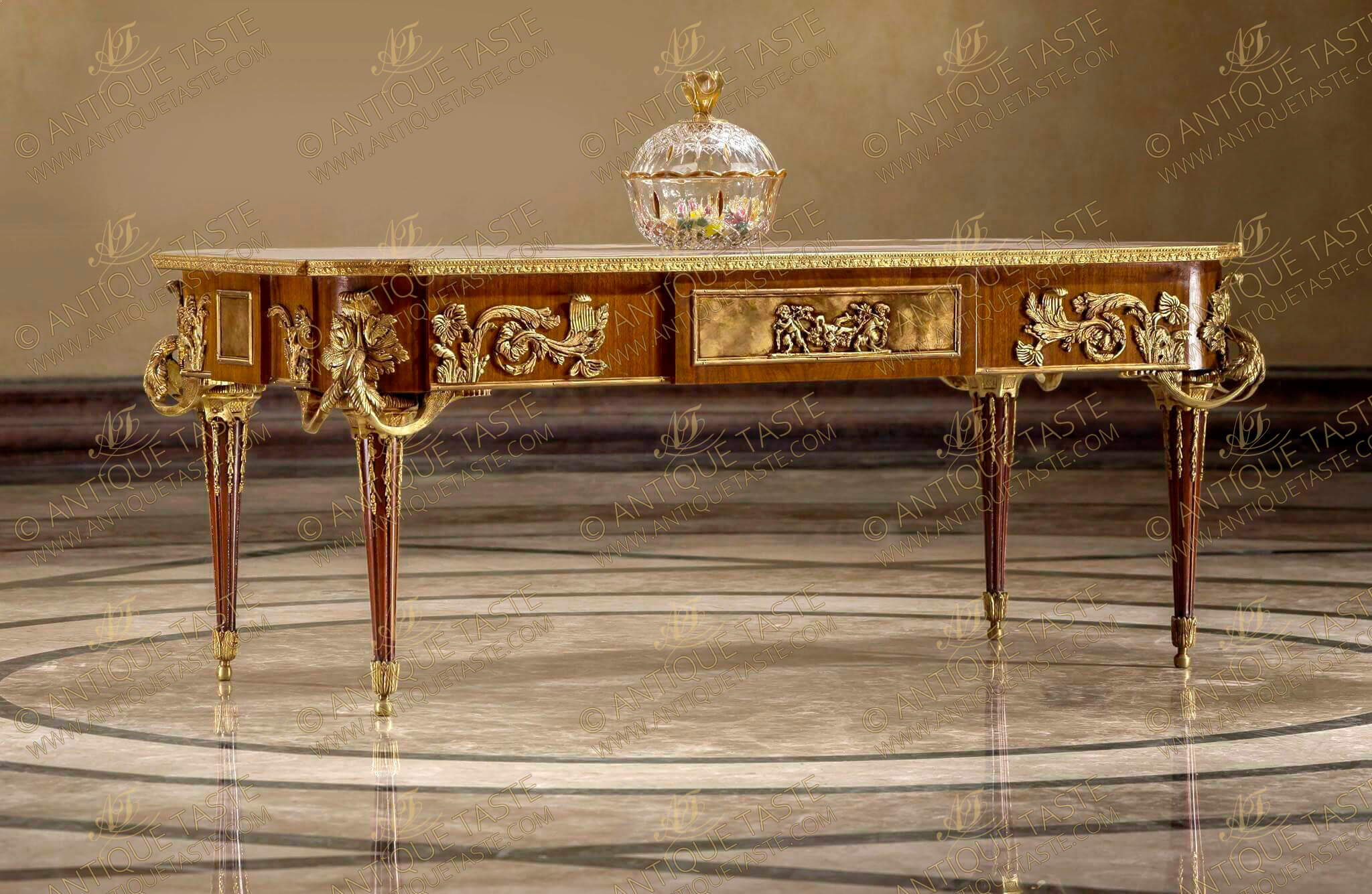 La Table Aux Muses Reproduction,French Louis XVI style ormolu-mounted veneer inlaid and marquetry center-coffee-table, after the model by Jean-Henri Riesener, By François Linke, Paris, Late 19th Century, the shaped rectangular top each corner with a circular floral ormolu rosette, the ormolu border above a central frieze drawer to the front, the sides and back each centered by a rectangular gilt-ormolu tablet embellished with finely high-relief cast gilt-ormolu mounts depicting bacchanalian cherubs at play, on tapering  legs and acanthus-cast sabots